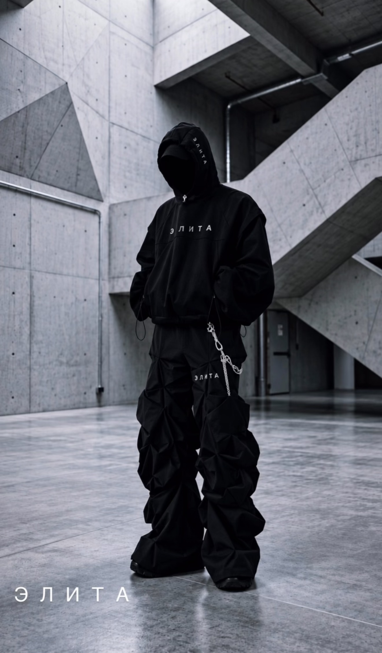 Faceless hooded figure in black in monumental concrete architecture